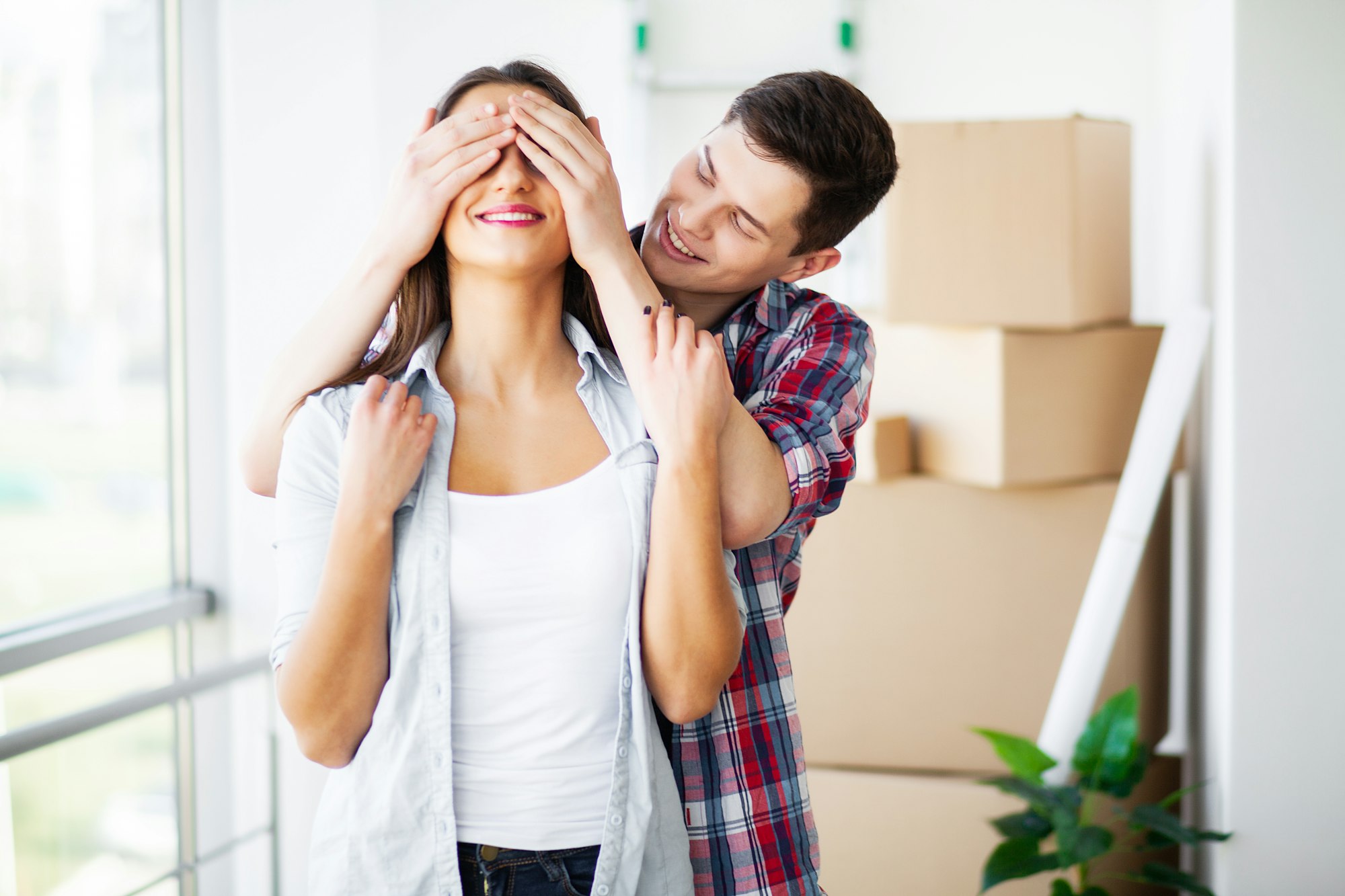 Young happy couple moving into their new home. They unpacking and cleaning new home